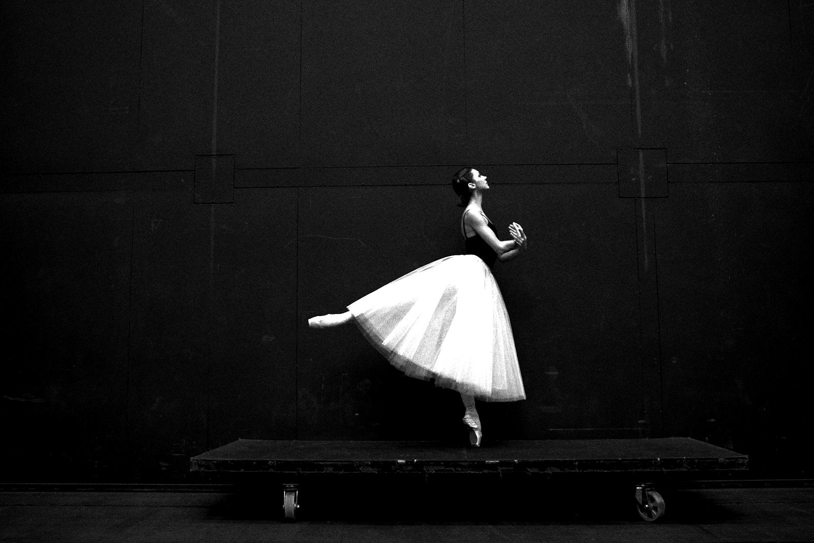 A ballet dancer on pointe behind the curtain