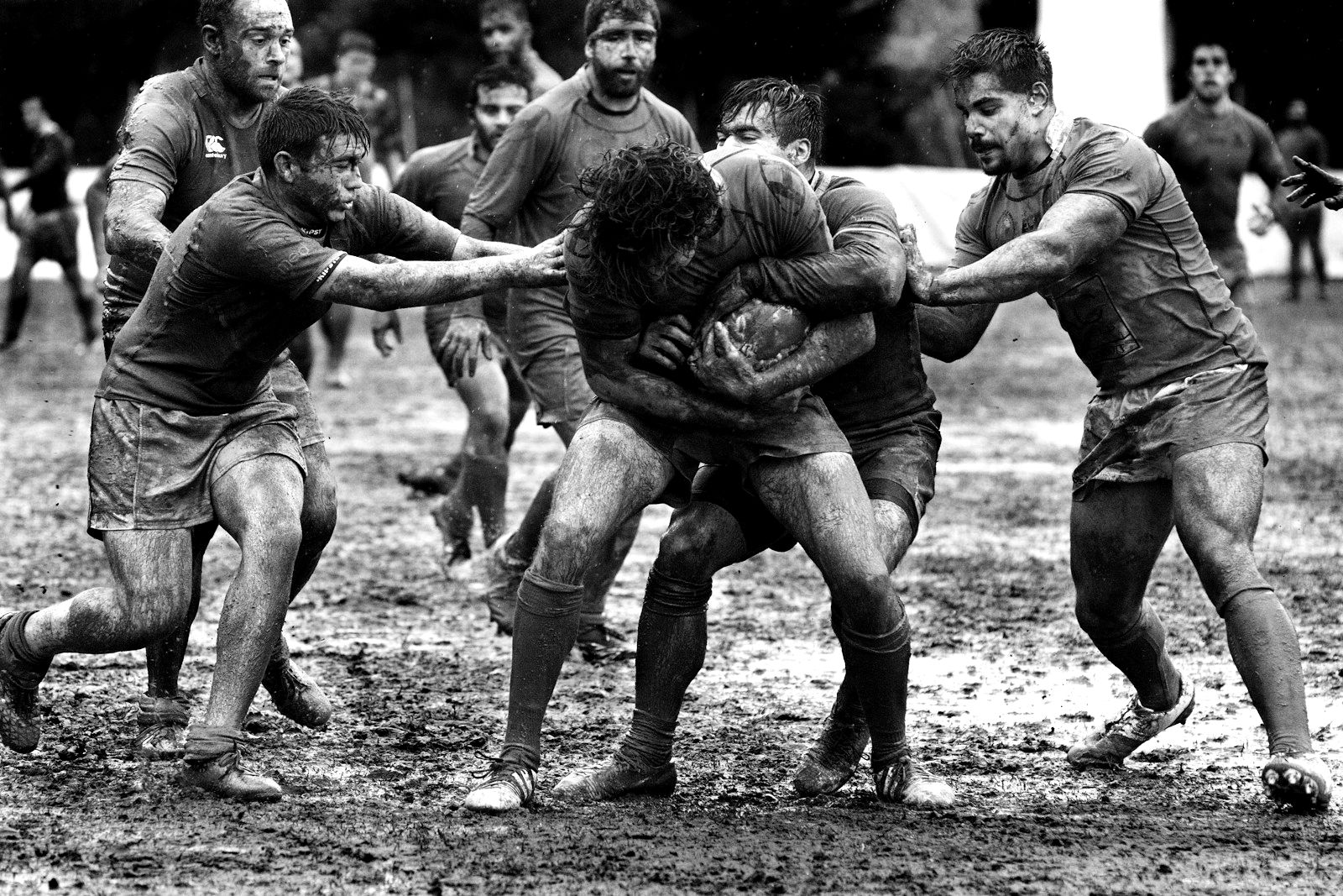 Rugby players colliding in deep mud